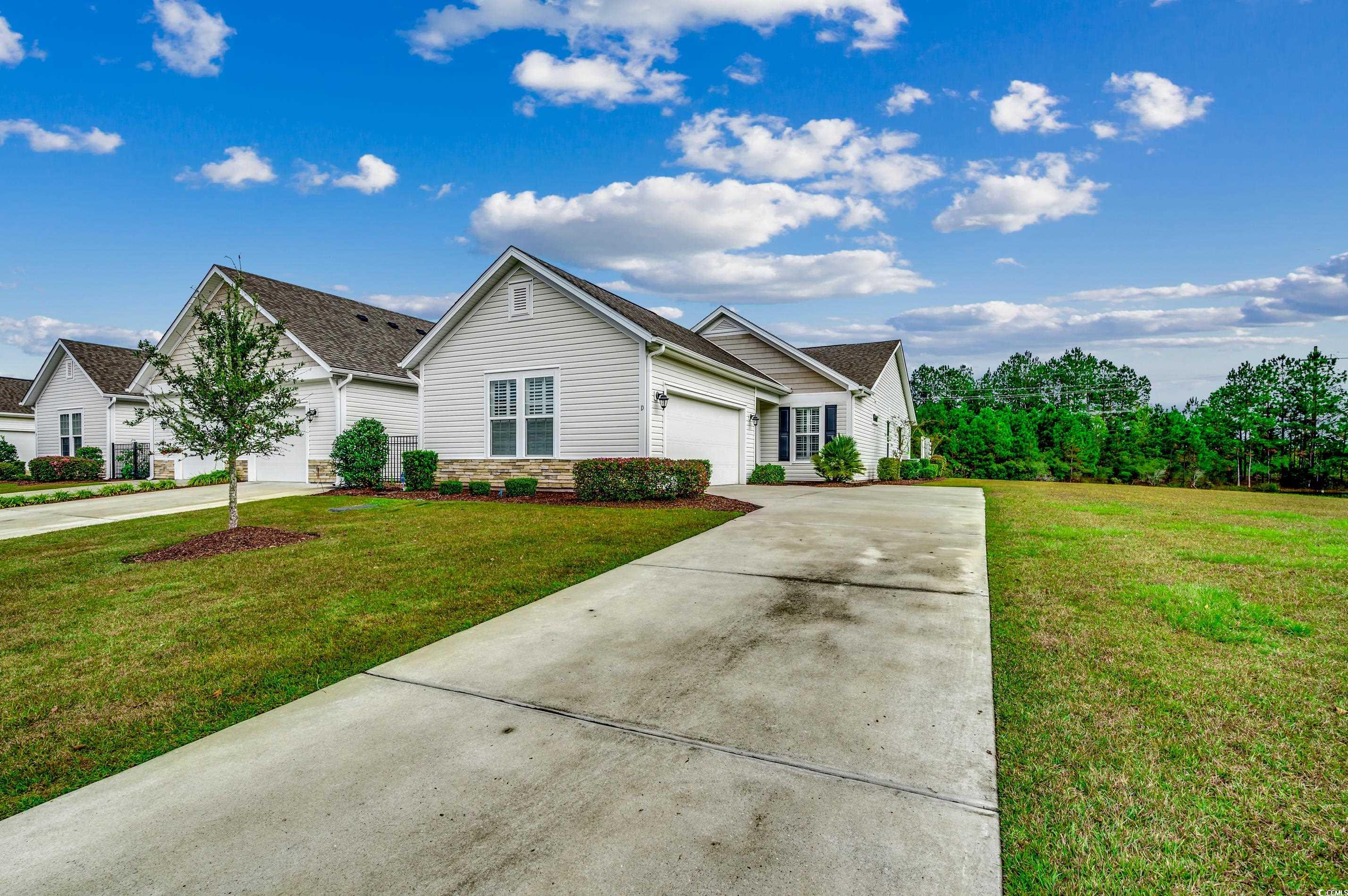 View of front of condo with a front yard and a gar