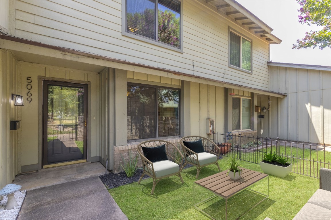 a view of a patio with couches table and chairs and potted plants