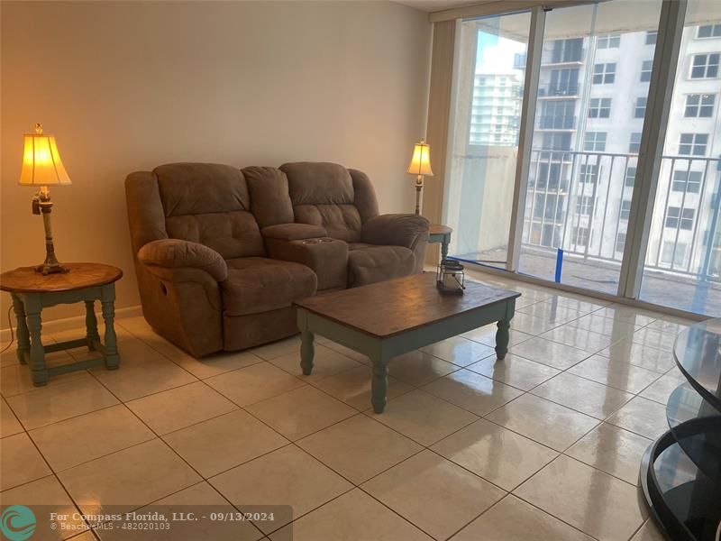 a living room with furniture and a floor to ceiling window