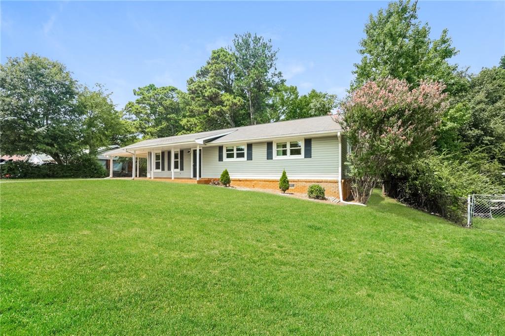 a view of house with backyard and a garden