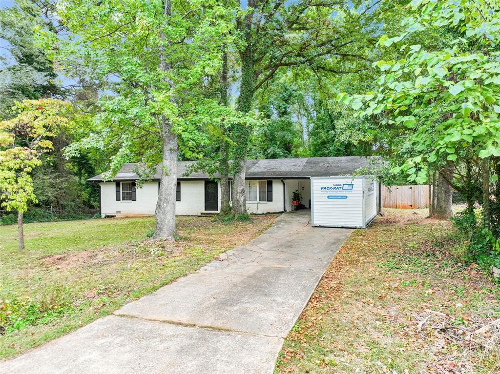 a front view of a house with a yard and trees