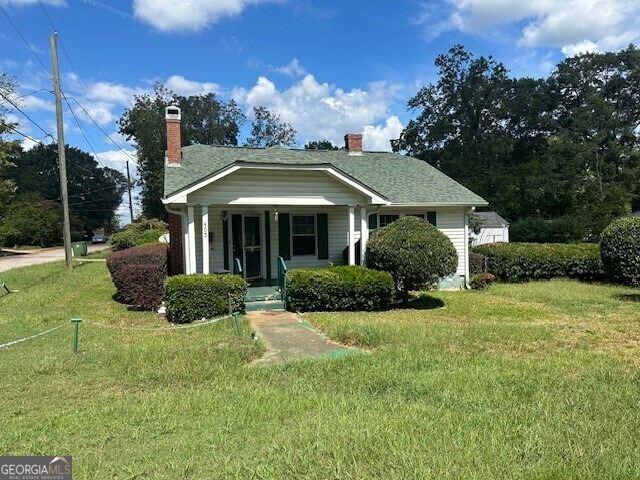 a front view of a house with yard and green space