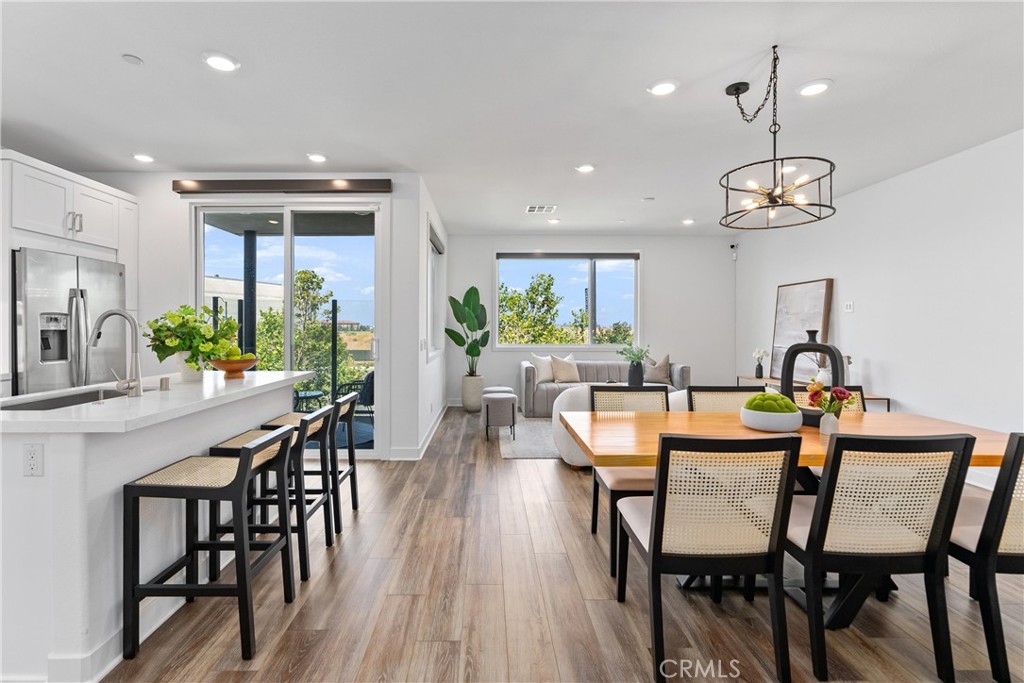 a dining room with furniture a chandelier and wooden floor