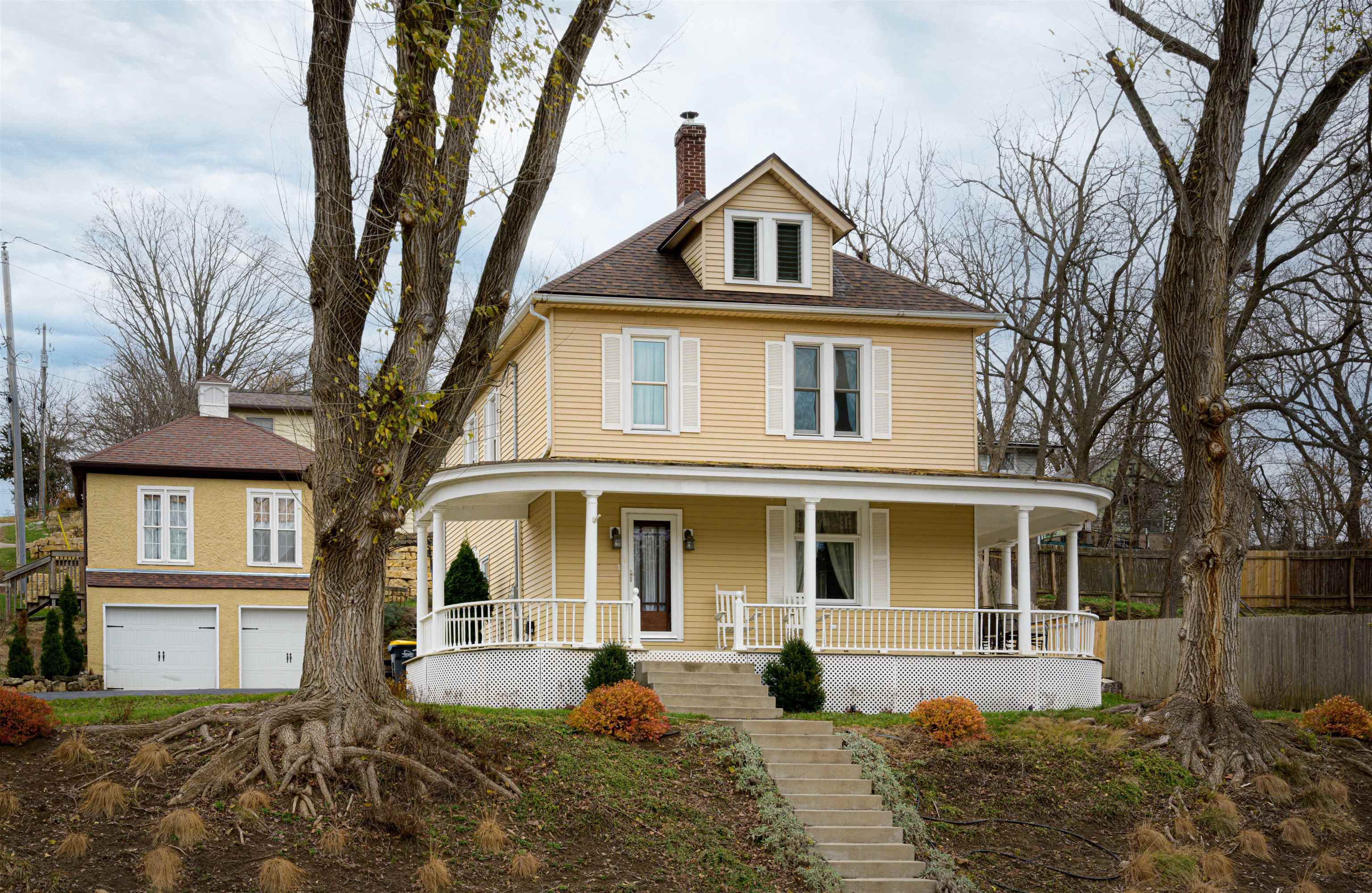 a front view of a house with yard and trees