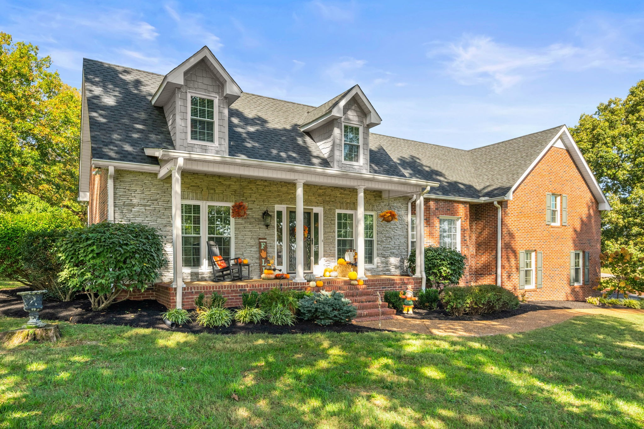 a front view of a house with a yard and outdoor seating