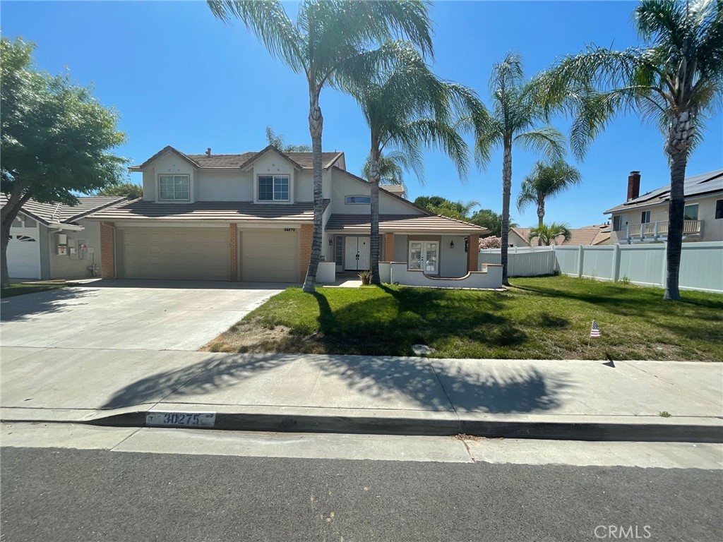 a view of a house with a yard and palm trees