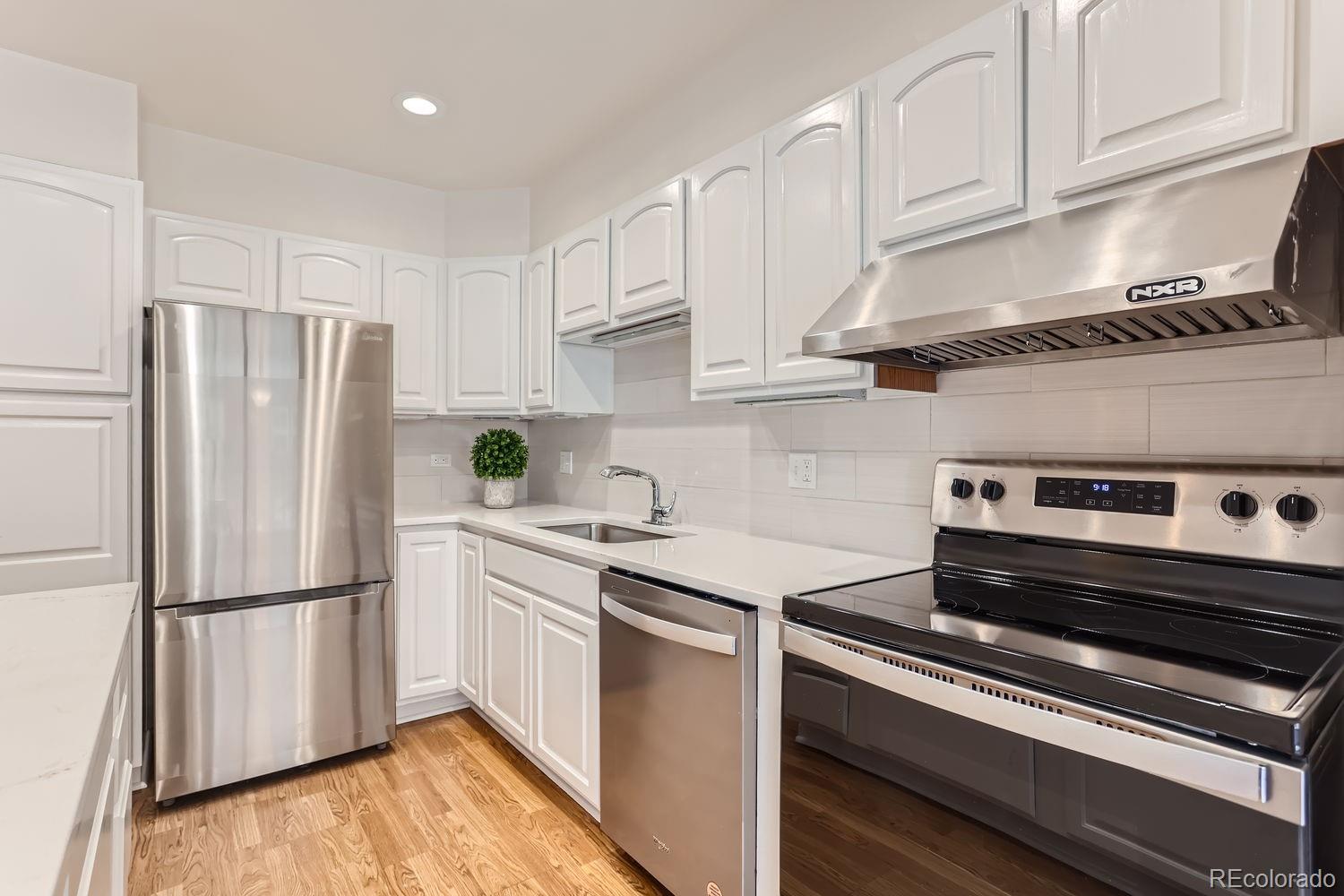 a kitchen with a refrigerator stove and white cabinets