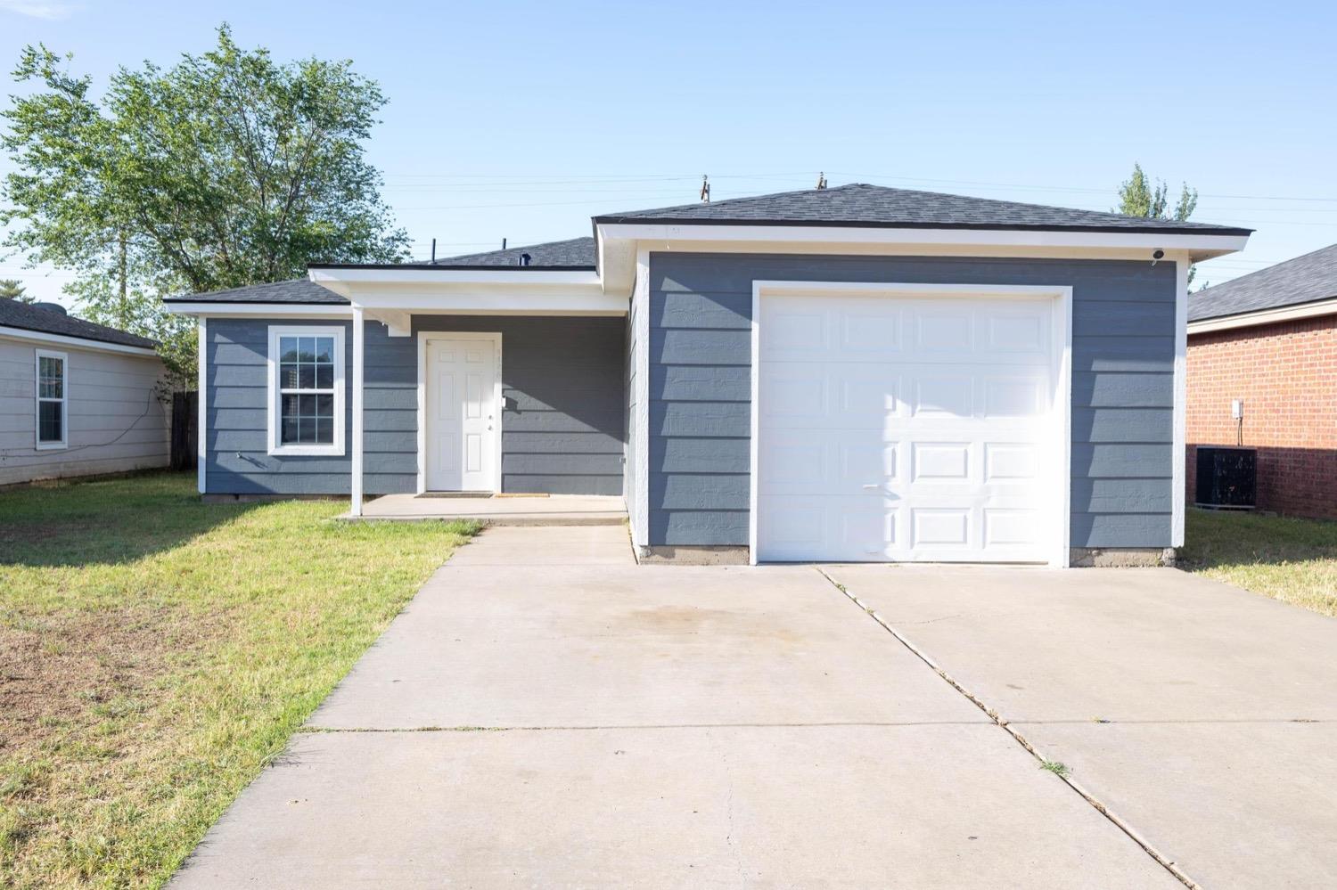 a front view of a house with a garage and a yard