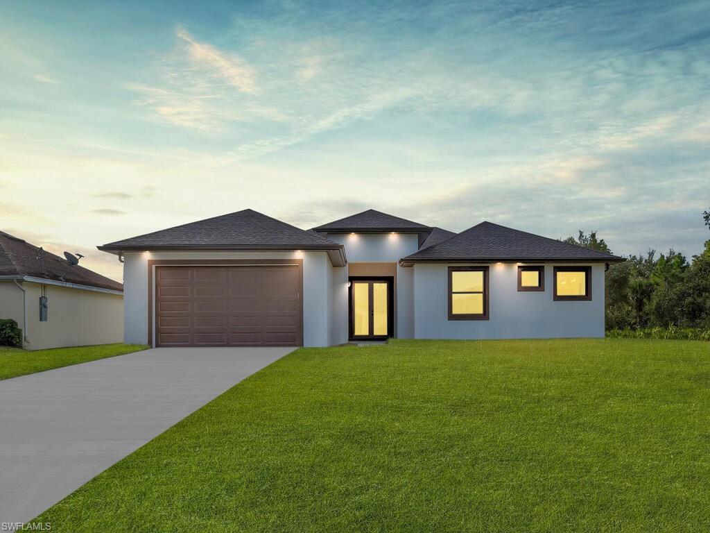 Prairie-style house featuring a yard and a garage