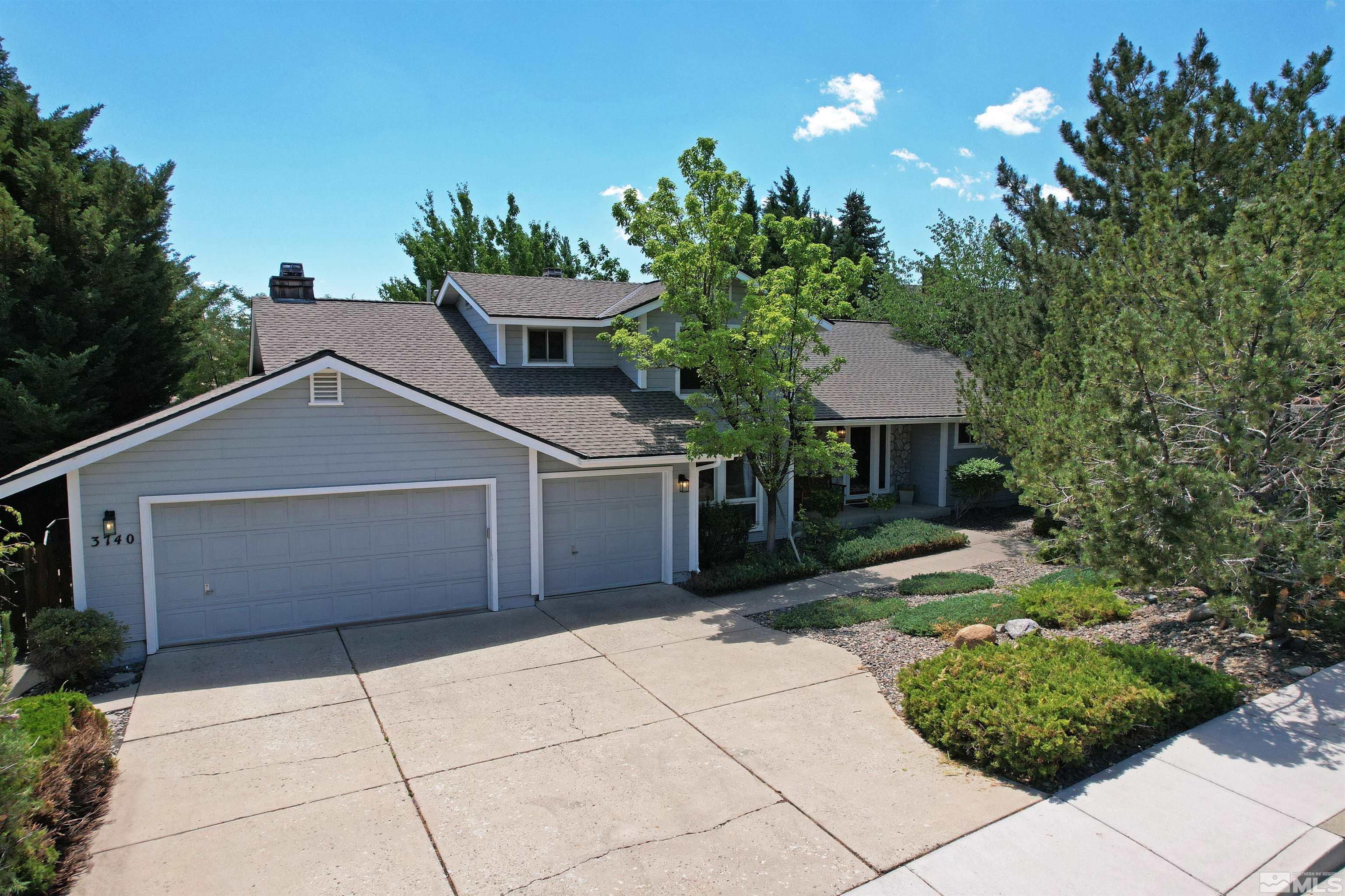 a front view of a house with a yard and a garden