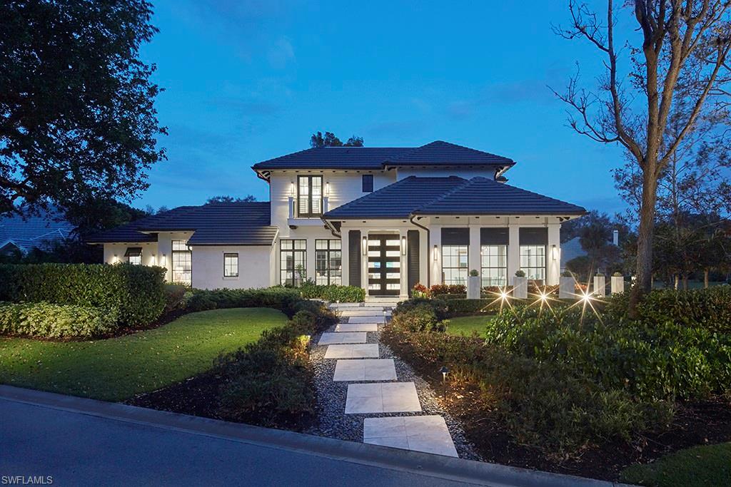 a front view of a house with a yard and green space