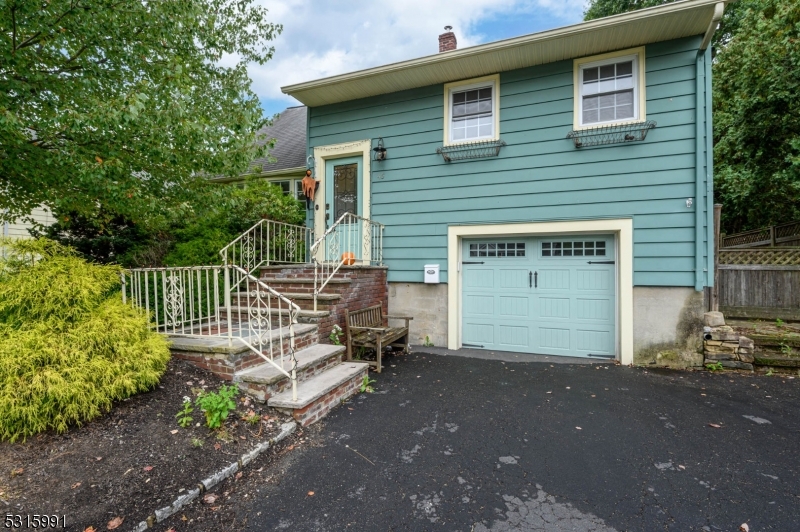 a view of a house with a small yard and wooden fence