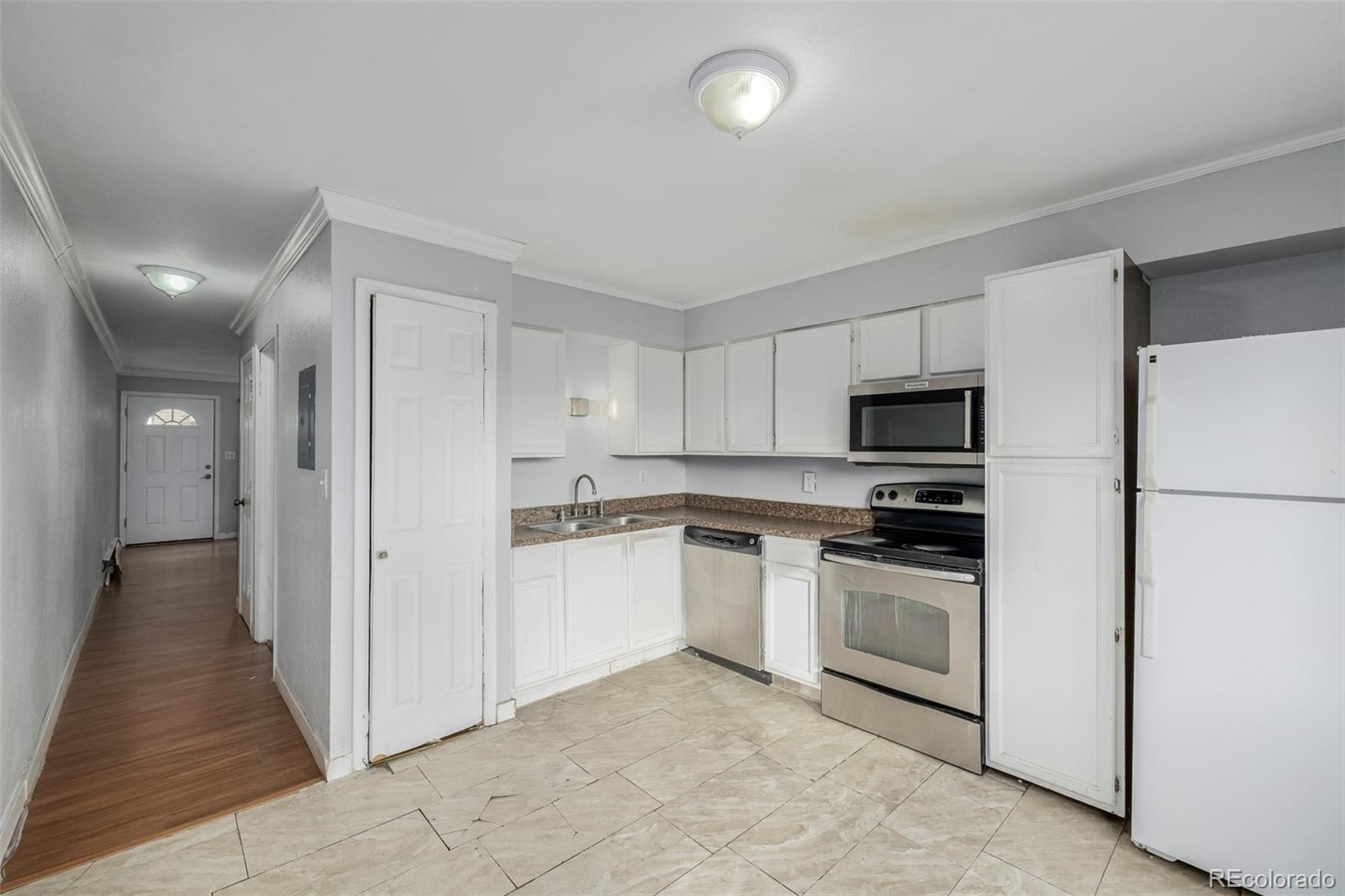 a kitchen with granite countertop white cabinets and white appliances