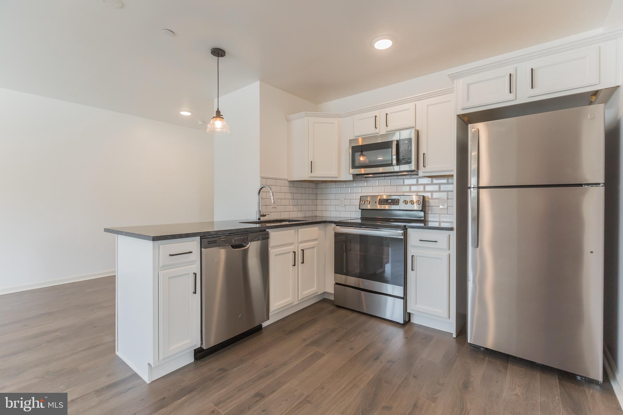 a kitchen with a refrigerator and a stove top oven