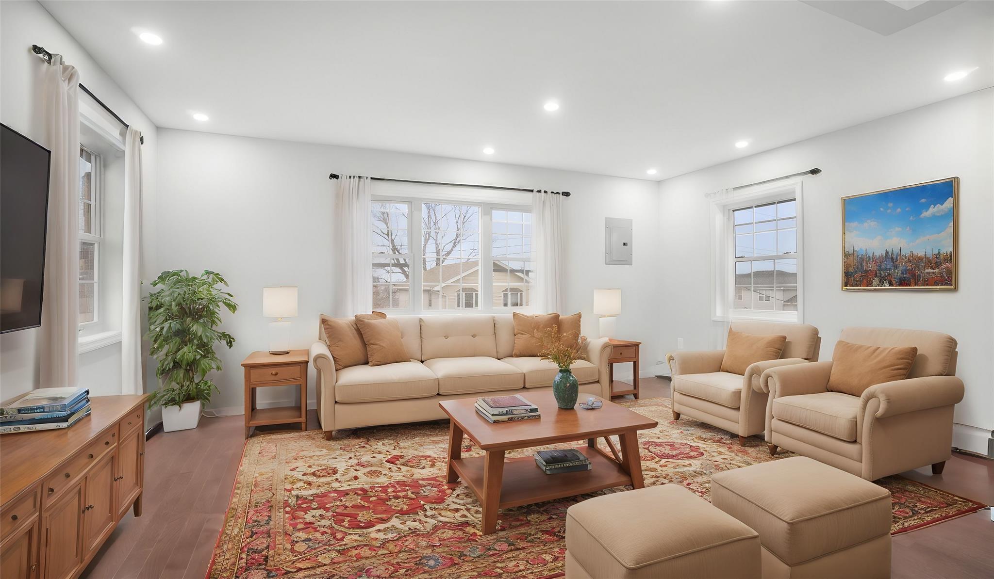 Living room with hardwood / wood-style flooring, electric panel, and a wealth of natural light