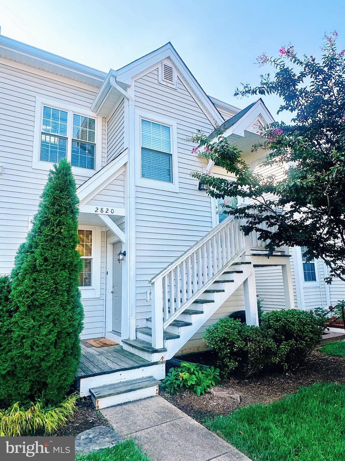 a front view of a house with plants and garden