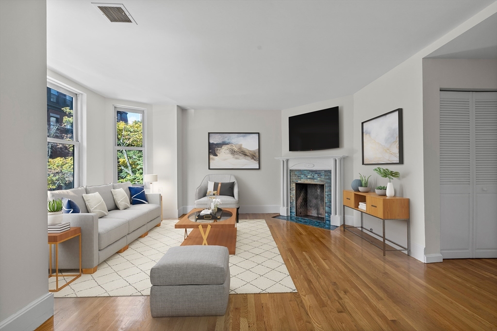 a living room with furniture a flat screen tv and a fireplace