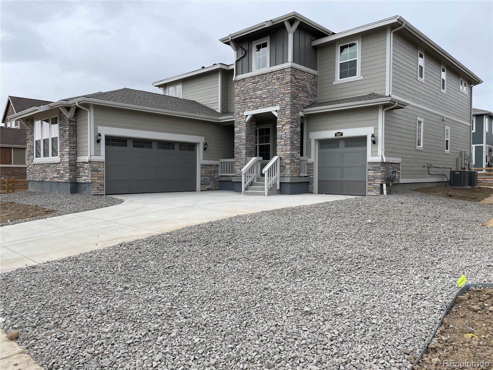 a front view of house with yard and trees in the background