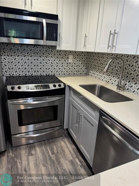 a kitchen with a stove microwave and sink