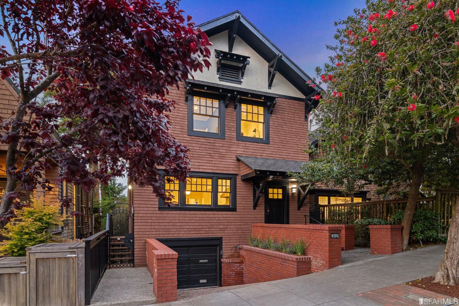 a front view of a house with a tree