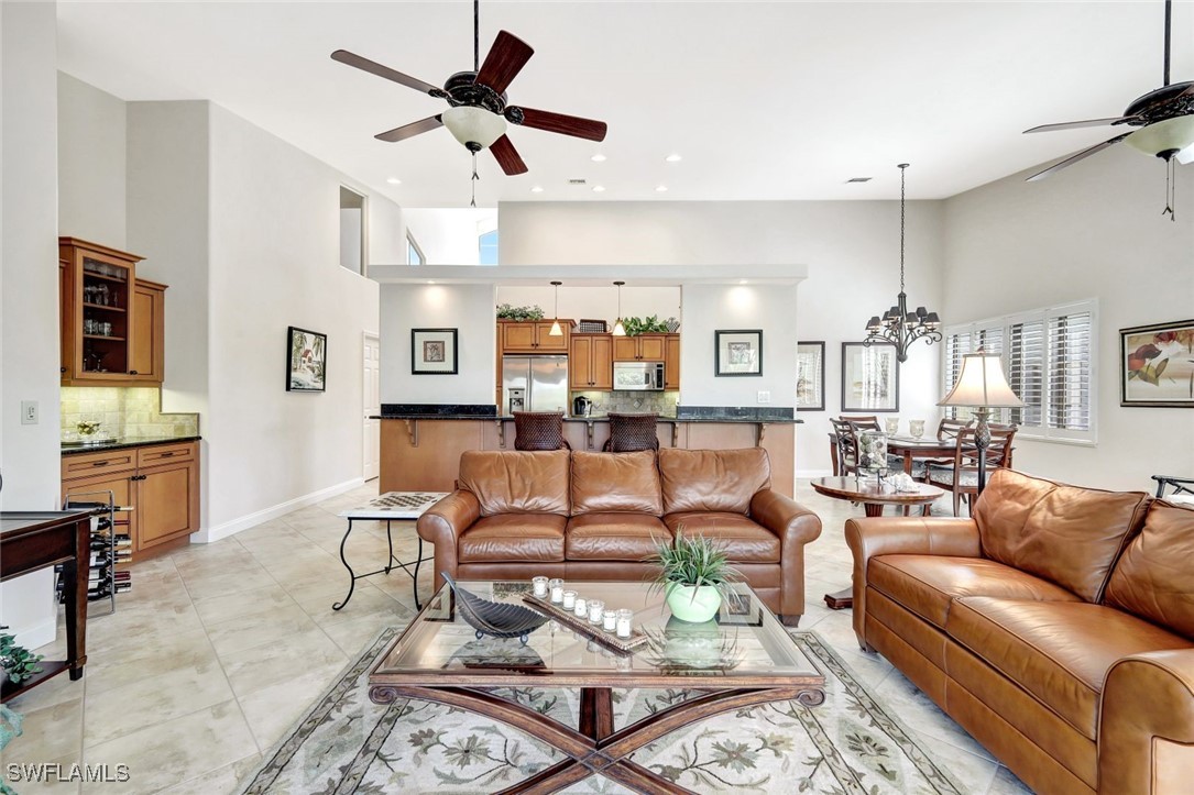 a living room with furniture kitchen view and a chandelier