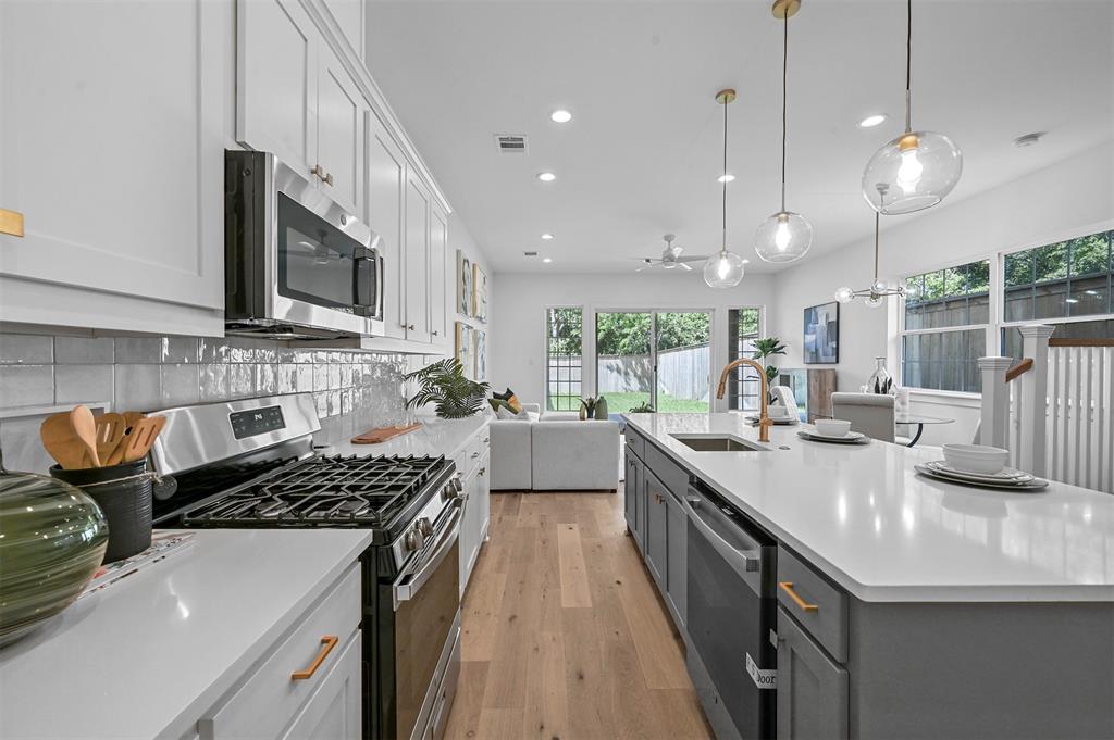 a kitchen with kitchen island granite countertop a sink a counter space appliances and cabinets