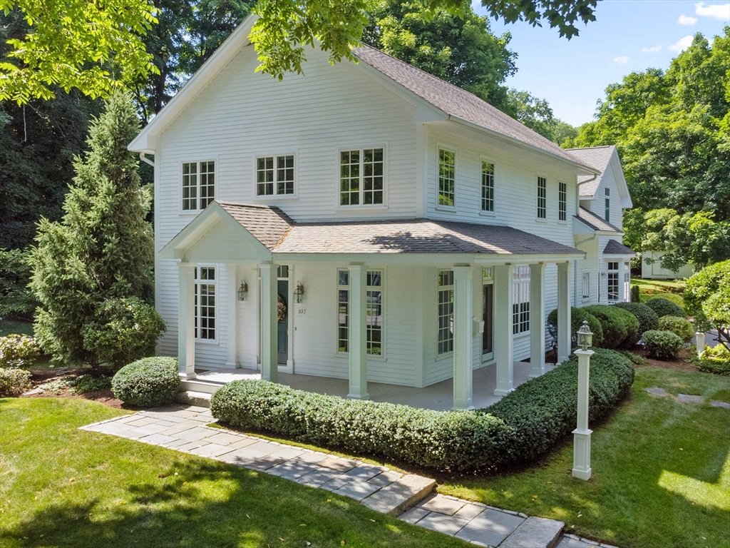 a view of a white house with a yard and plants