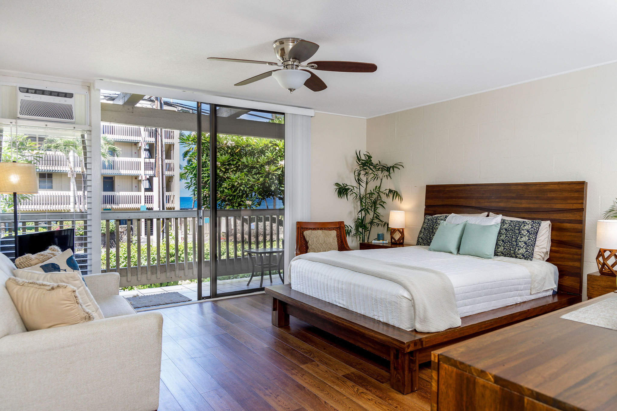 a bedroom with a large bed and a chandelier fan