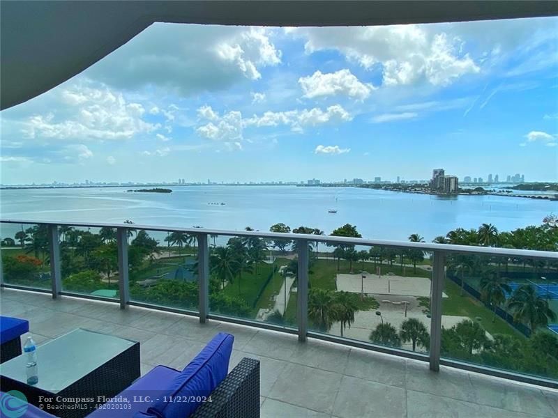 a view of a lake with couches in the patio