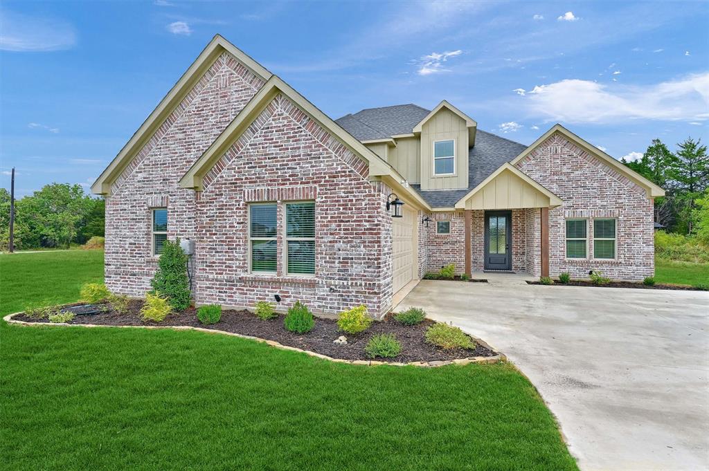 a front view of a house with a garden and yard