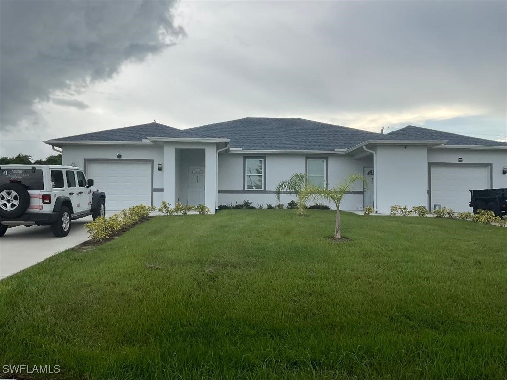 a front view of house with yard and car parked