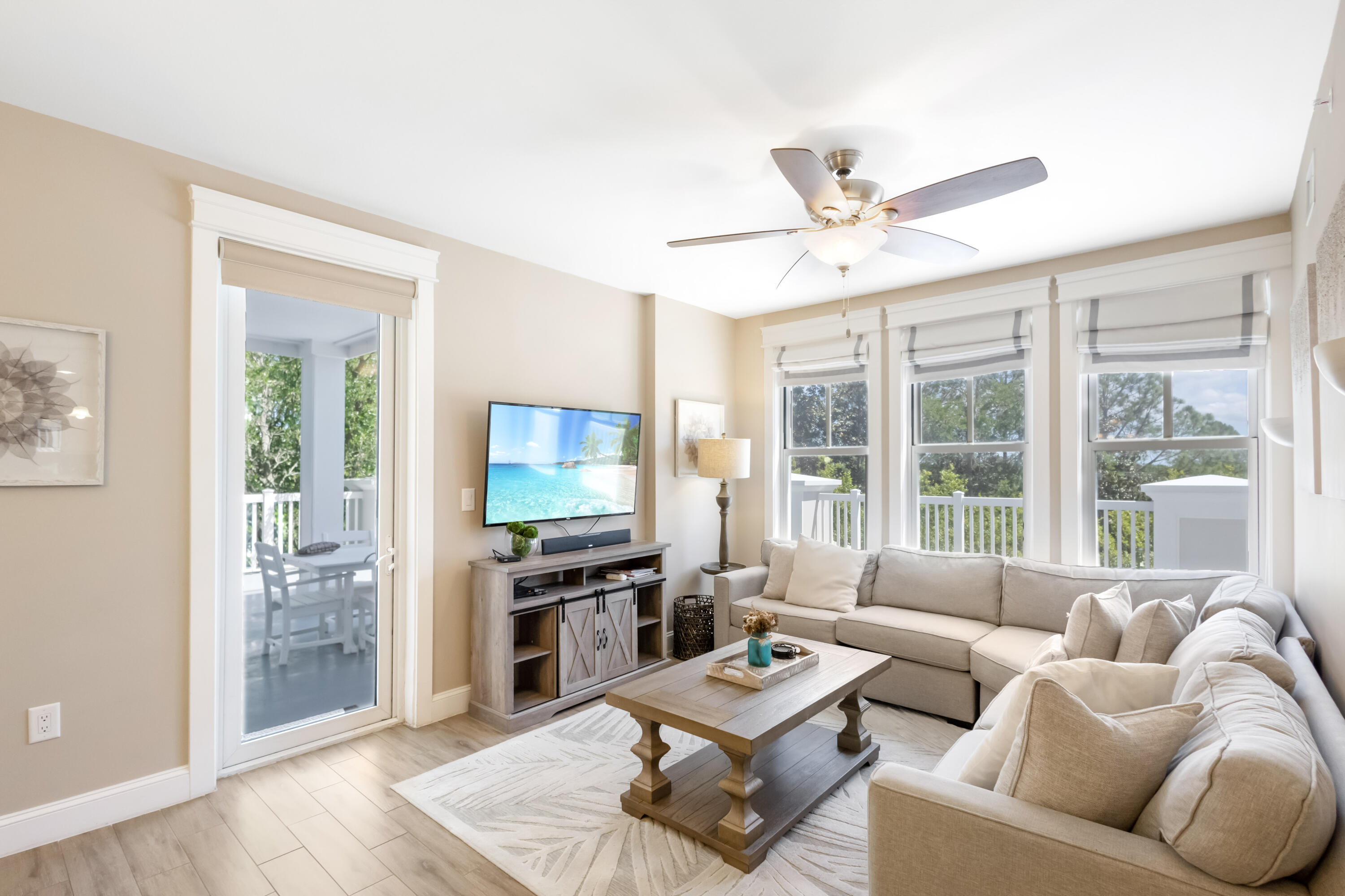 a living room with furniture a flat screen tv and a large window