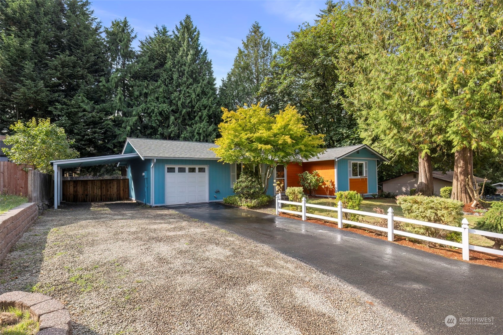 a view of a house with a yard and large tree