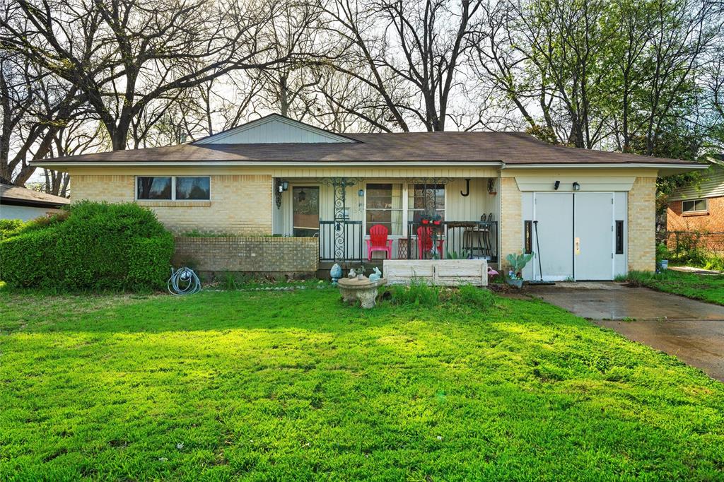 a front view of a house with a garden and trees