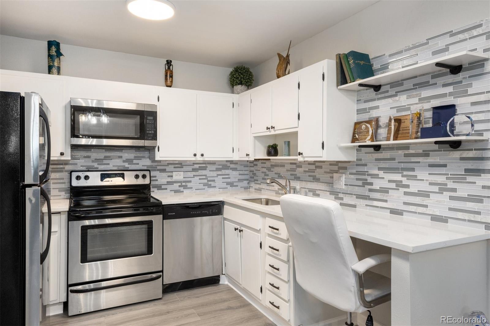 a kitchen with granite countertop a stove top oven and cabinets