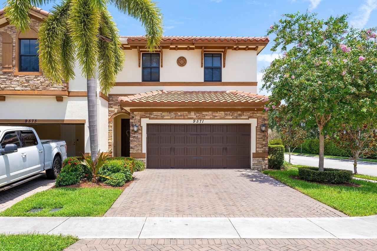 a front view of a house with a yard and garage