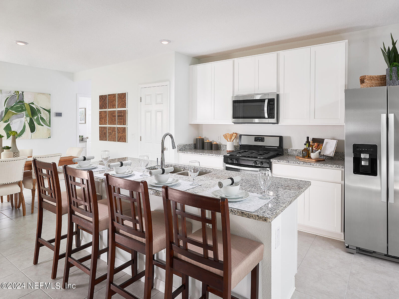 a kitchen with stainless steel appliances granite countertop a stove a sink a table and chairs