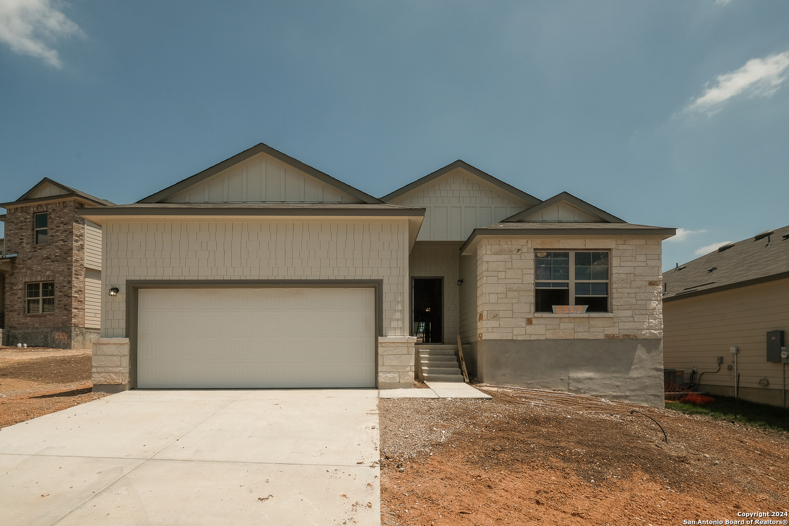 a front view of a house with a yard and garage