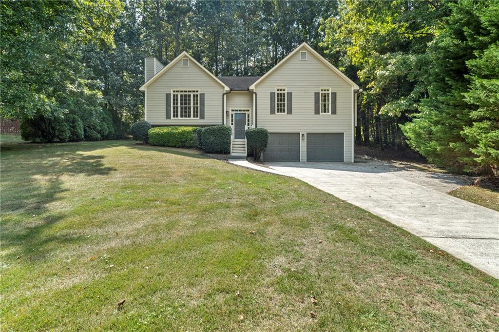 a front view of a house with yard and green space