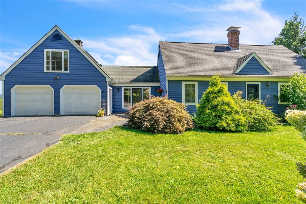 a front view of house with yard and garage