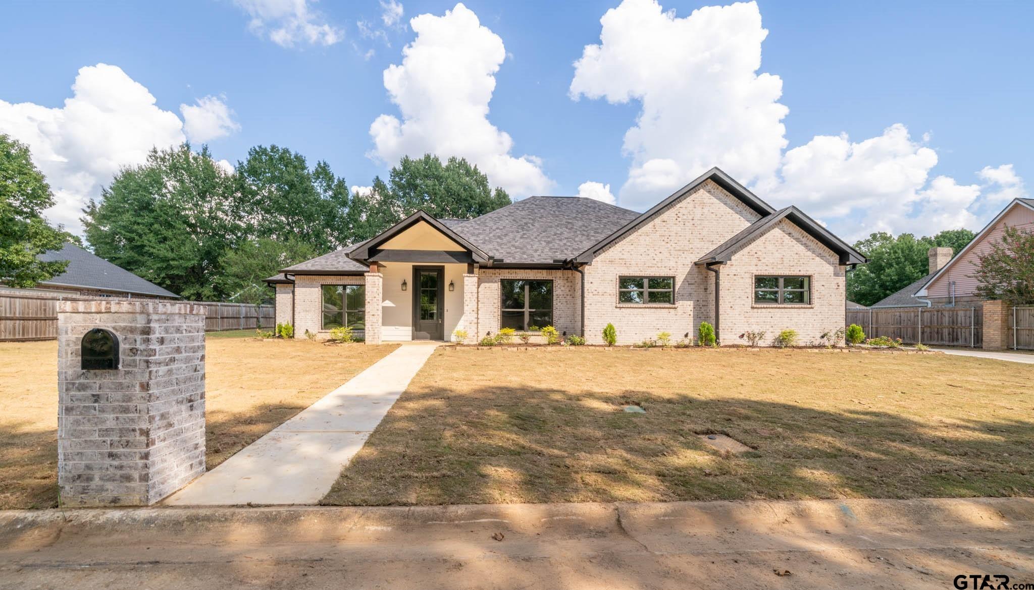 a front view of a house with a yard and trees