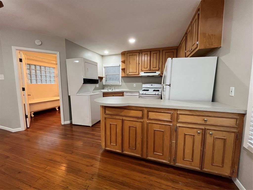 a kitchen with granite countertop a sink cabinets and wooden floor