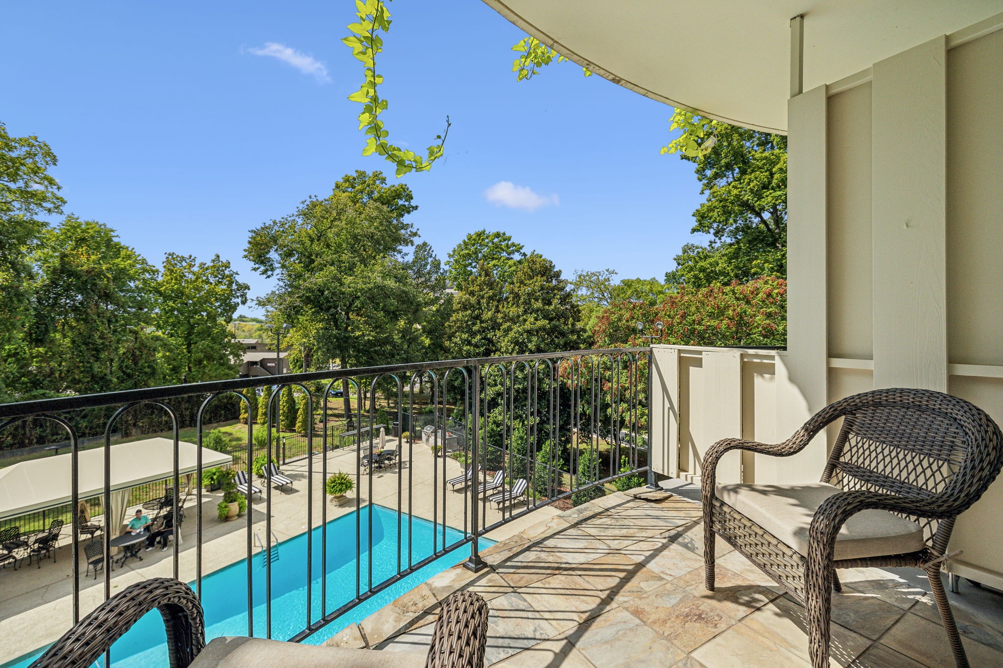 a balcony with wooden floor table and chairs