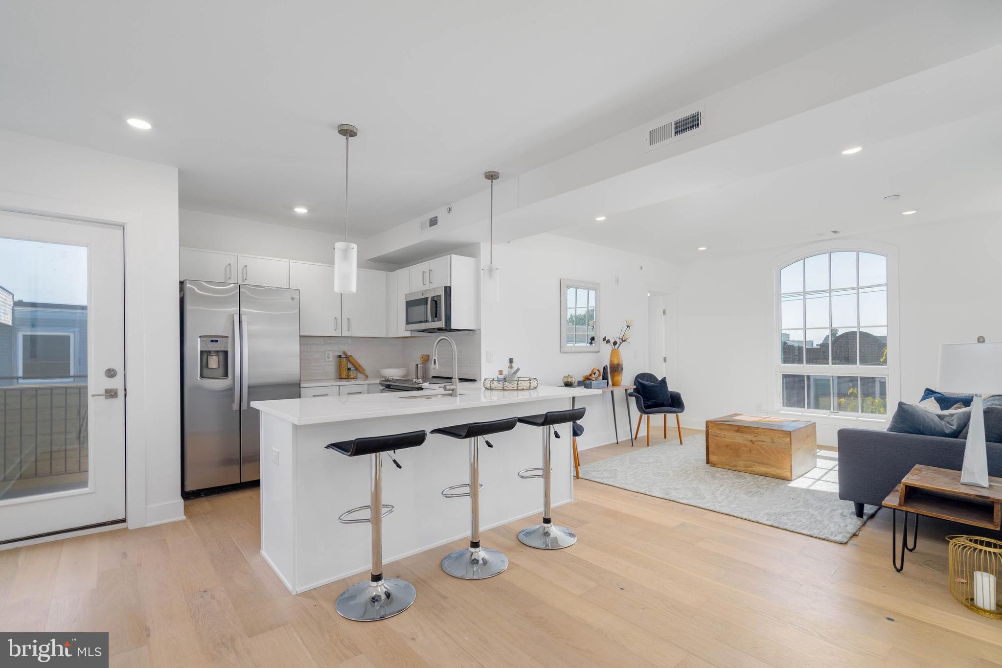 a living room with furniture a dining table and kitchen view