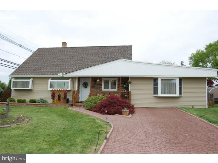 a front view of a house with a garden and trees