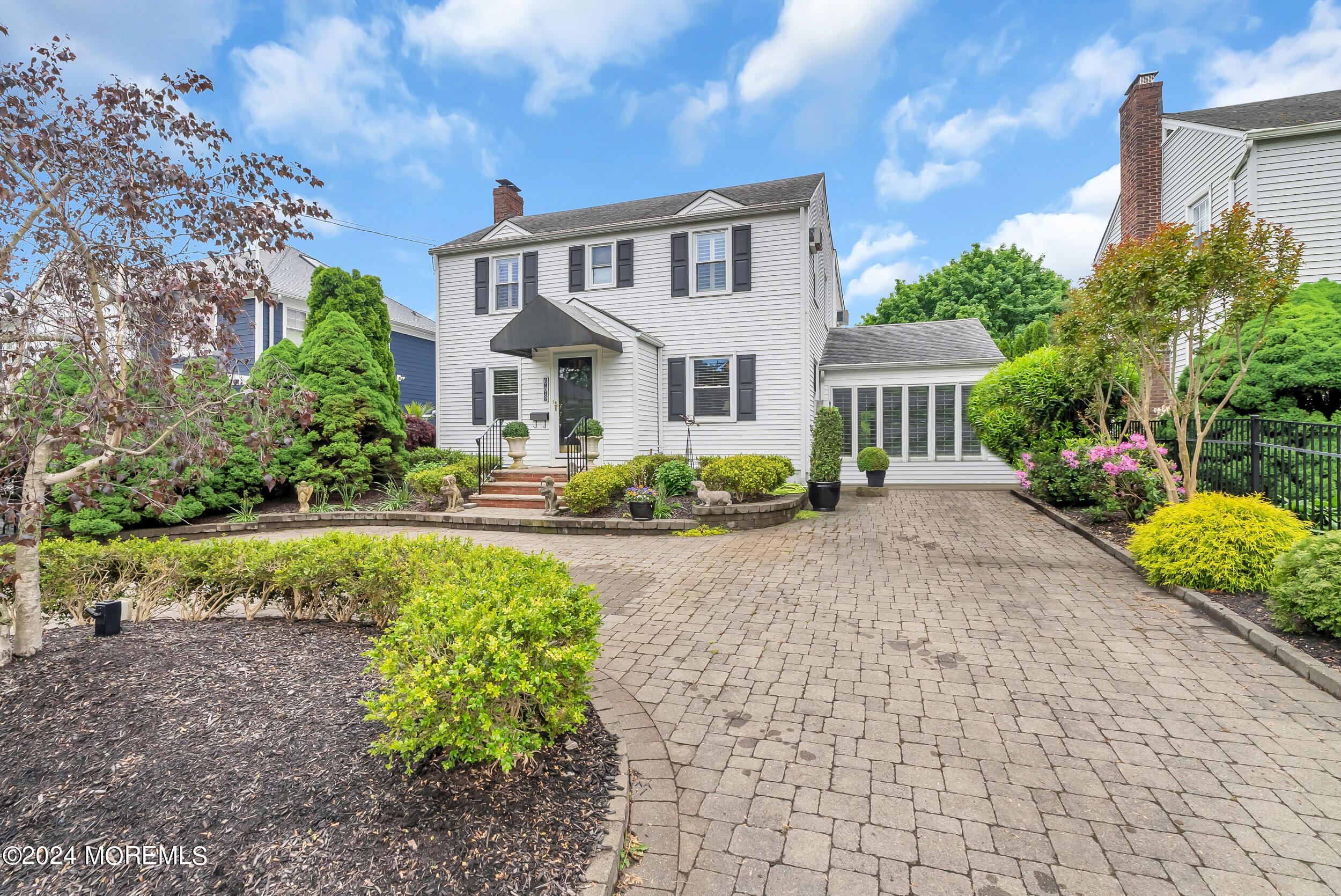 a front view of a house with a yard and a garden