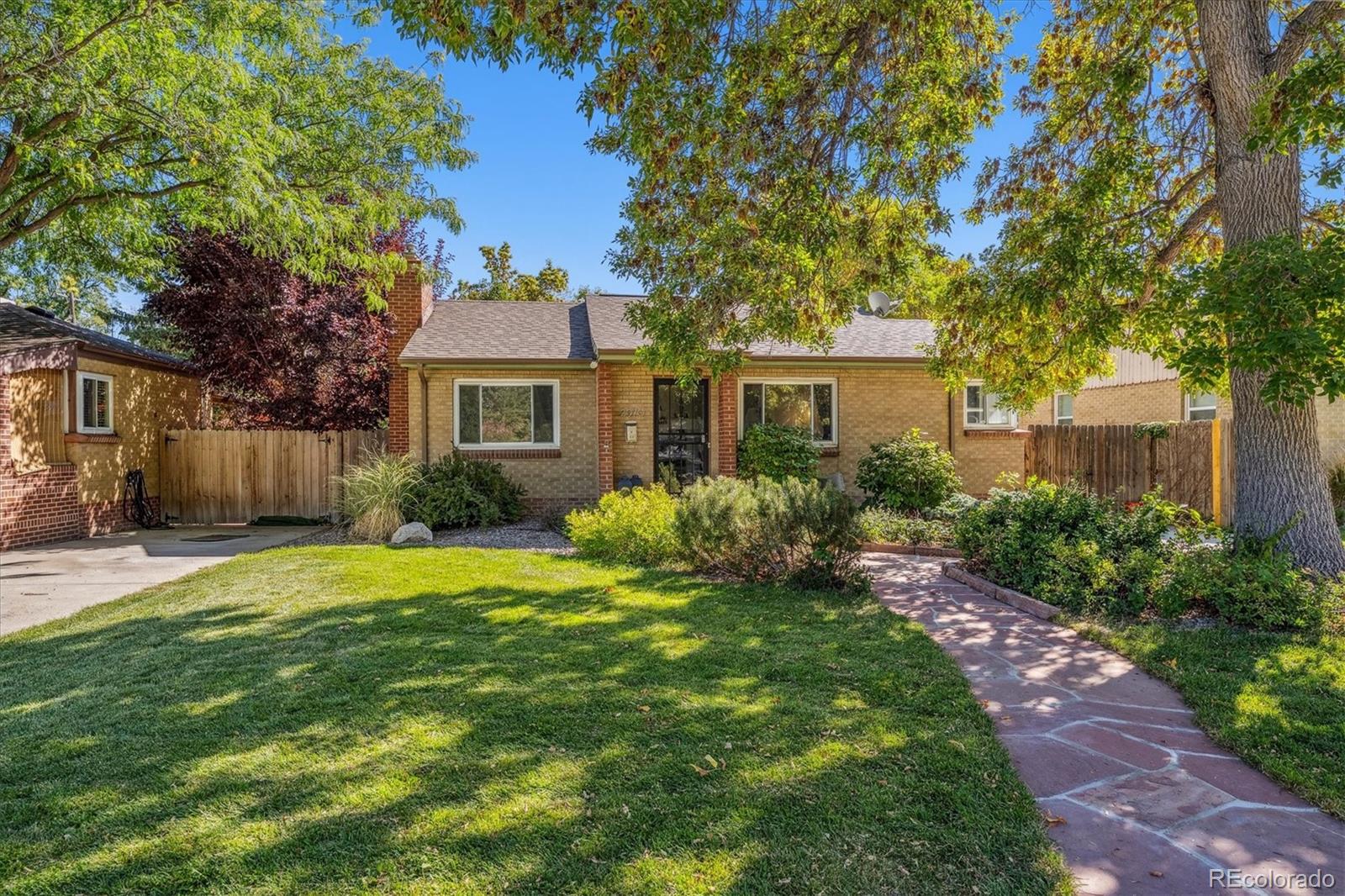 a front view of a house with a yard and trees