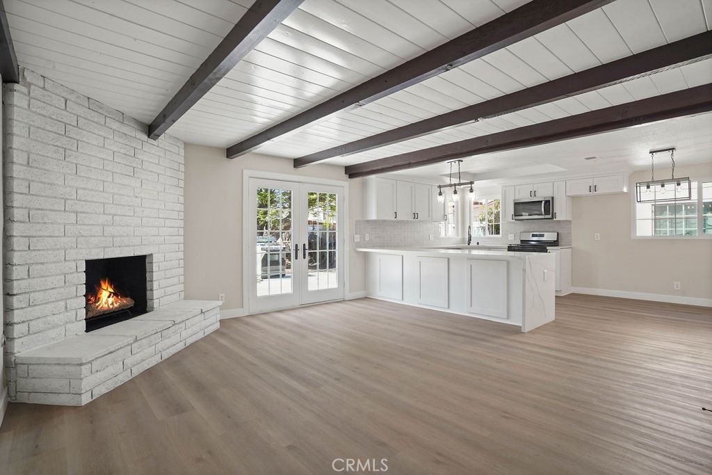 a view of open kitchen with granite countertop a stove top oven a chimney and a fireplace