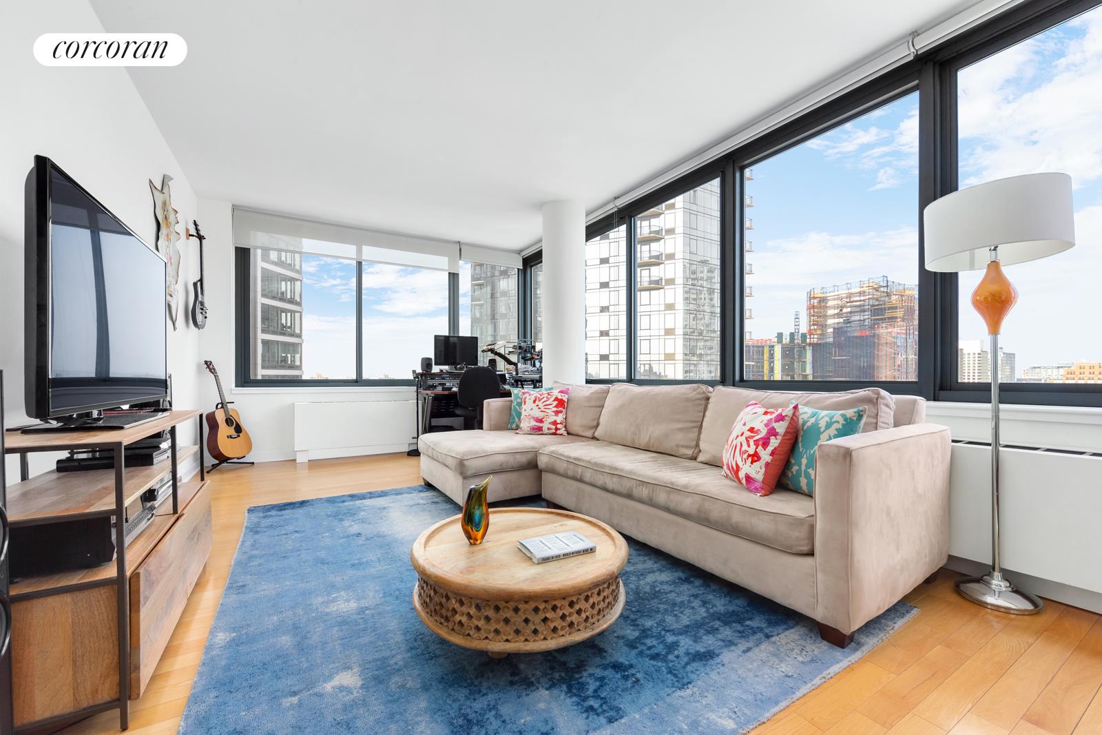 a living room with furniture a fireplace and large windows