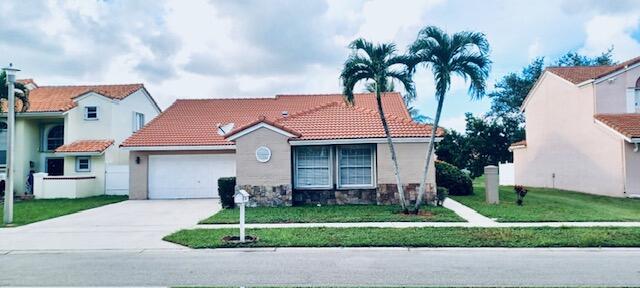 a front view of a house with a garden and plants